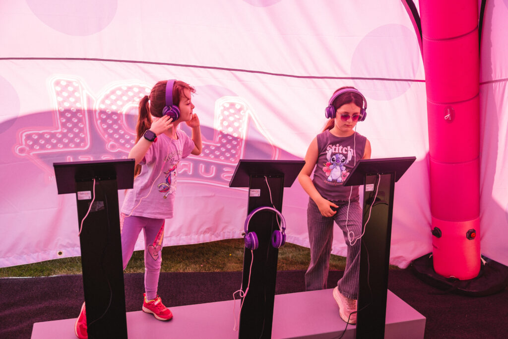 Zwei Kinder spielen auf der TOGGO Tour 2026 im L.O.L. Surprise! Zelt mit der Musik-App